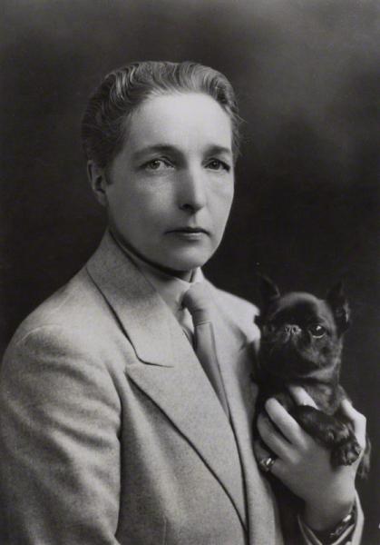 black and white photograph of Radclyffe Hall, sitting holding a dog