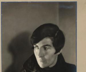 Alix Strachey with slicked hair, dressed in a leather jacket and black scarf